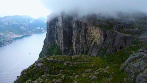 Aerial drone flight over Pulpit Rock a.k.a. Preacher’s Chair. The famous tourist place Preikestolen in the mountains of Norway. Taken in summer in foggy weather