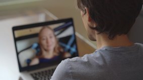 A man talks through video conferencing while he is sitting at home during the coronavirus self-isolation period. Social distancing concept