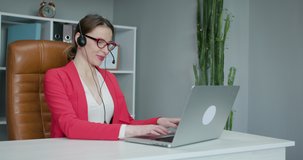 Young woman wears headset conference calling on laptop talks with online teacher studying, working from home. Distance education concept