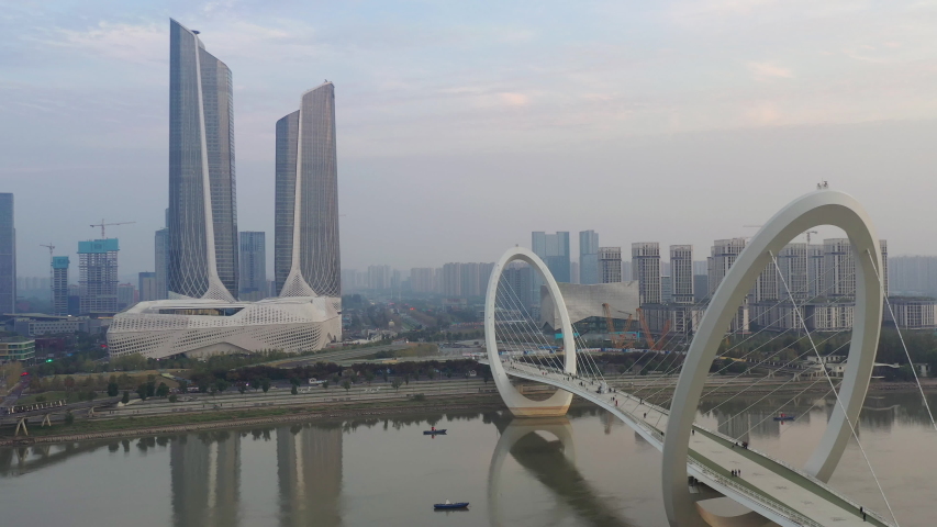 sunset time nanjing city famous international youth cultural center pedestrian riverside bridge aerial panorama 4k china