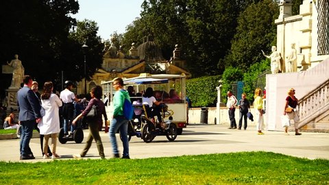 Rome, April 25, 2019: Tourist train passes near the entrance to the Roman museum of the BORGHESE GALLERY, with works by Bernini, Canova and Michelangelo, on a sunny day