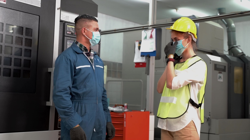 Worker Labor man and woman and wearing protection mask face and safety helmet and wearing suit green reflective safety dress in high tech clean factory. Concept of smart industry worker operating. | Shutterstock HD Video #1052391796