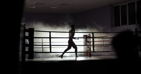 Dedicated athlete doing a shadow fight on boxing ring, practicing muay thai martial art, preparing for a fight - sports, martial arts concept 4k footage