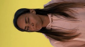Intelligent black girl suddenly comes to an excellent idea. Yellow background. Video with Vertical Screen Orientation 9:16