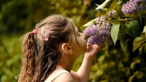 
Cute Baby Girl Adorable Little Smelling Flower.Happy Beautiful Kid With Pretty Face Having Fun.Cheerful Preschool Funny Child Daughter Enjoy Spring In Botanical Garden Smell Lilac. Cute Baby Girl Fun