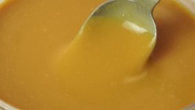 liquid caramel dripping from a spoon into a large cup
