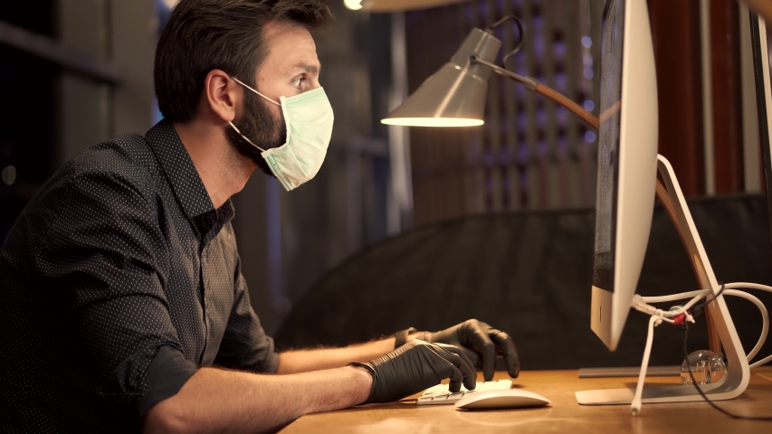 Man In Face Mask Working In Office.Businessman In Mask Protection Epidemic Coronavirus.Remote Working With Camera Chatting Colleagues Internet Online Meeting Conference Webinar.Distance Working Webcam | Shutterstock HD Video #1052433337