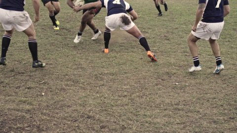 Rugby players tackling for ball possession at sports arena. Rugby players in action during a championship match.
