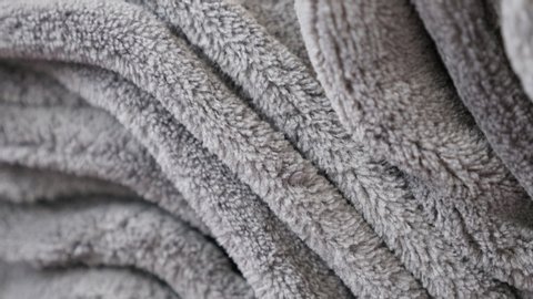 Pile of polar fleece blankets close-up 4K tilting footage