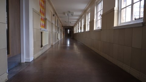 4K: Empty School or College Corridor with no people. The Long hallway is deserted in this place of eductation. Low Tracking Shot. Stock Video Clip Footage