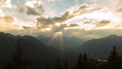 Lockdown time lapse shot of river and mountains against cloudy sky at sunrise - Banff, Canada