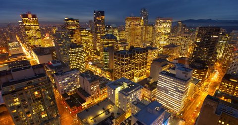 Lockdown time lapse shot of illuminated buildings and street in city at night - Vancouver, Canada
