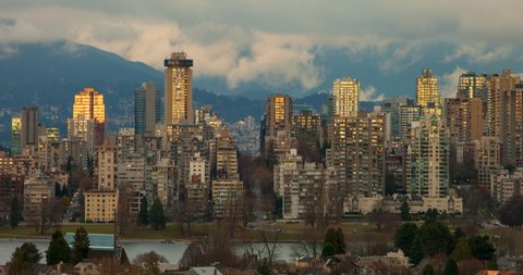 Time lapse shot of buildings near mountain against cloudy sky at sunset - Vancouver, Canada