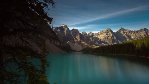Panning time lapse shot of mountain range reflecting on lake against sky - Banff, Canada