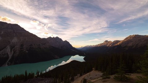 Time lapse shot of lake amidst mountains and forest against sky during sunset - Banff, Canada