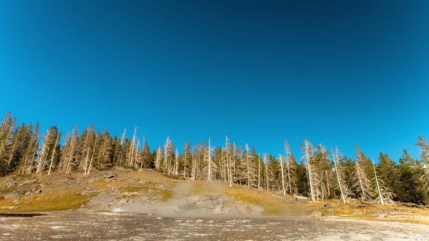 Lockdown time lapse shot of rainbow over geyser splashing at national park on sunny day - Yellowstone National Park, Wyoming