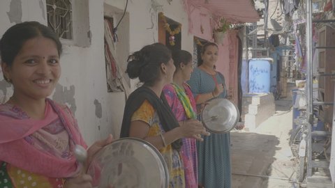 A group of women/ ladies standing outside their houses and banging utensils/ plates/ clapping to show appreciation/ respect/ salute to health workers, doctors, nurses etc. Mumbai, India (May 2020)