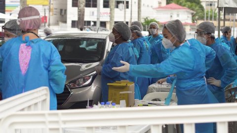 Santos / Brazil 2020 - Covid-19 doctors in the PPE protective and coronavirus patients are tested at a drive thru clinic. Face masks and hand sanitizer shown.

