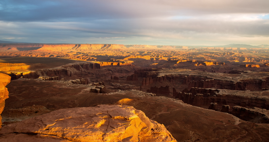 Aerial panning shot of Grand View Point Overlook against cloudy sky at sunset - Arches National Park, Utah