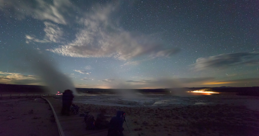 Lockdown time lapse shot of people on boardwalk by geyser against sky at night - Yellowstone National Park, Wyoming