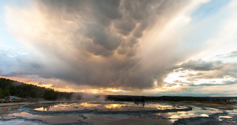 Lockdown time lapse shot of mammatus clouds over geyser against sky during sunset - Yellowstone National Park, Wyoming