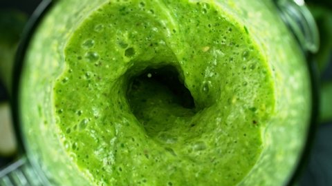 Green fresh smoothie blended in blender, top view. Healthy eating concept. Super slow motion filmed on high speed cinematic camera.