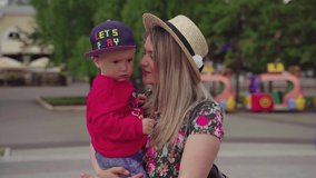 happy family. mom and son happiness love teamwork concept lifestyle. gentle touching slow motion video. son little boy hugs mom girls outdoors.