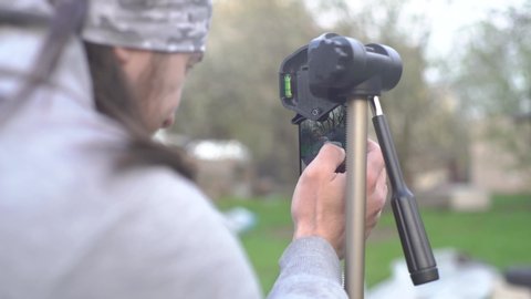 The guy prepares the phone for video shooting, a smartphone on a tripod