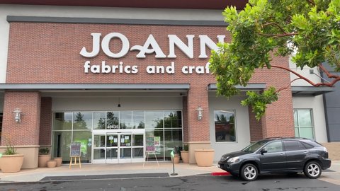 Fremont, CA / USA - May 12 2020: Joann Fabrics and Crafts COVID-19 store front open for curb side. Wide video shot.