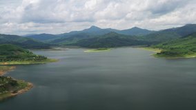 Aerial view of the river in the dam in the south of Thailand, Flying over the Dam on the river, Green fields and forests. Summer, cloudy sky. Aerial filming.