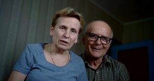 aged married couple is communicating by video call, looking at camera, portrait