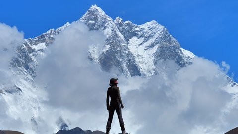 Woman hiker rises up to enjoying the mount Everest view  landscape and rising hands, static handheld shot