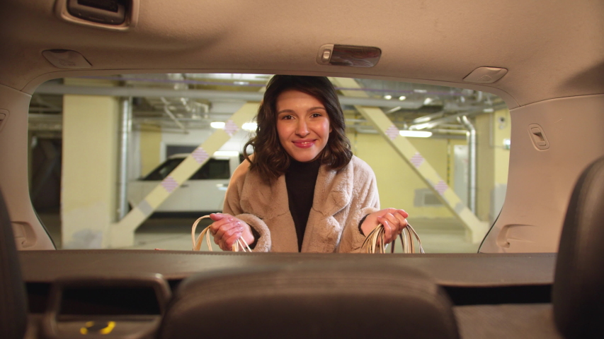 The girl smiles and holds packages with purchases in her hands