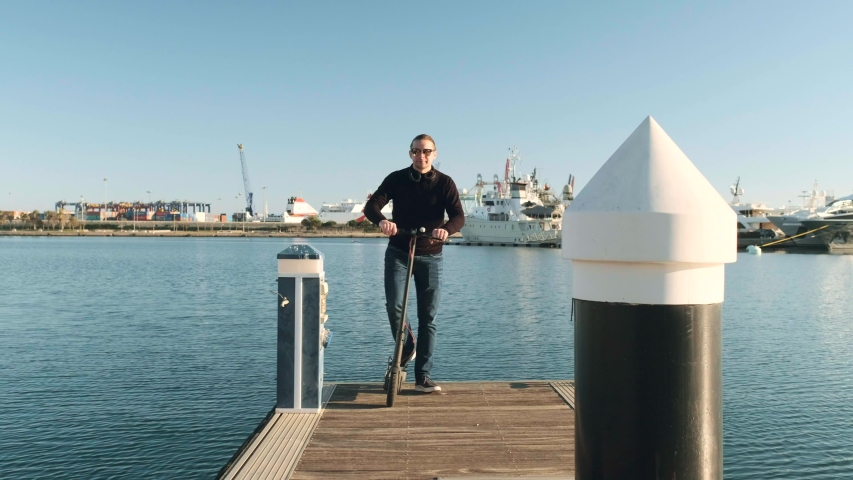 young business guy rides to work on an electric scooter