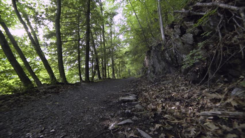 Female cyclists rides past the camera as it lifts upwards