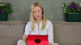 Video of a cute smiling blonde Caucasian girl conducting online communication through a tablet with headphones at home.