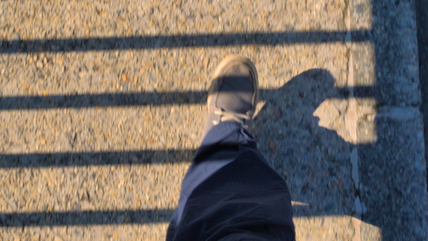 A feet walking on the side of the Kurobe Dam in Japan with the shadow of the fence | Shutterstock HD Video #1052507305