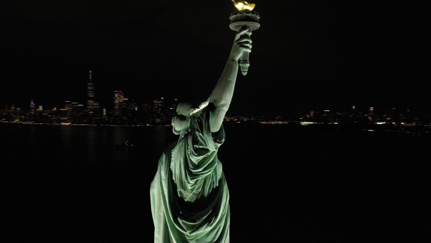 NEW YORK - CIRCA 2020 - An excellent orbiting aerial view shows the upper half of the Statue of Liberty in New York City, New York at night. | Shutterstock HD Video #1052515957