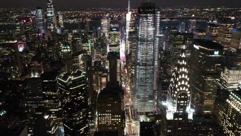 NEW YORK - CIRCA 2020 - An aerial view shows the skyline of 42nd Street in New York City, New York at night, highlighting the Chrysler Building.