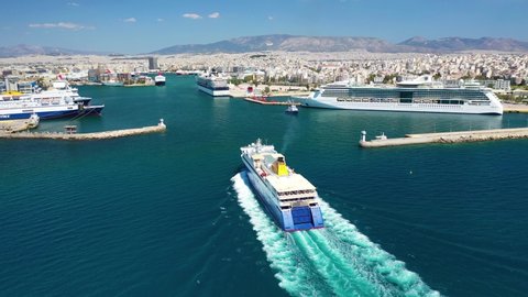 Piraeus, Attica / Greece - May 12 2020: Aerial drone video of passenger ferry reaching destination - busy port of Piraeus