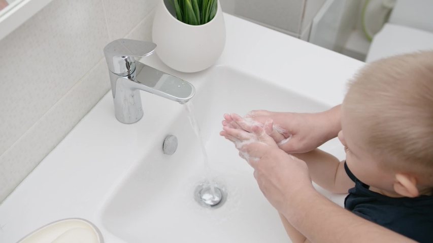 Mom washes baby hands with soap protecting against coronavirus to prevent COVID Royalty-Free Stock Footage #1052524690