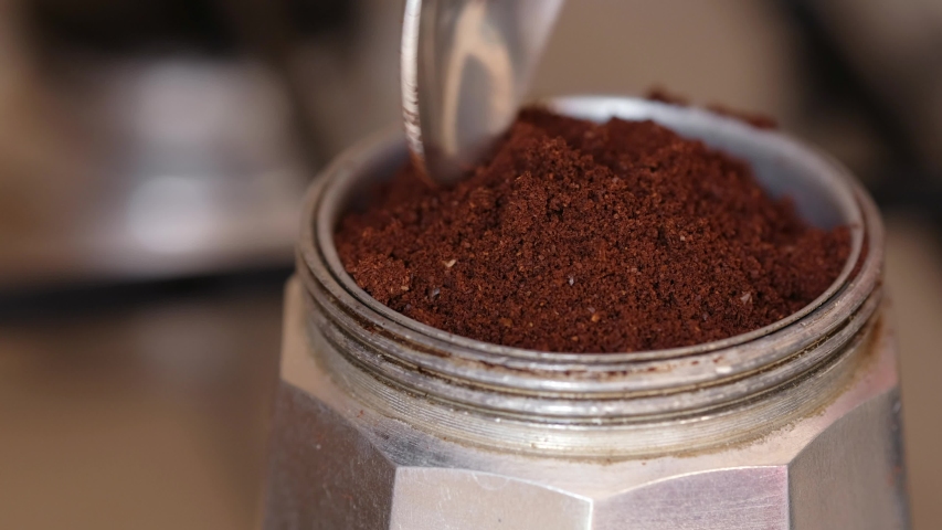 Putting coffee powder in the moka pot with the spoon. Making coffee at home. Close up shot | Shutterstock HD Video #1052530097