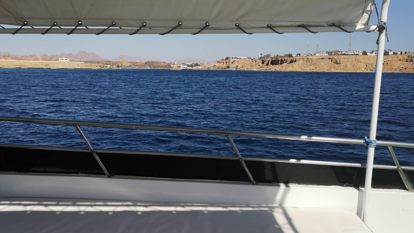 A trip on a yacht in the Red Sea in Sharm El Sheikh (Egypt) (7). Sea landscape of dark blue water and brown desert mountains on the horizon - view from the deck of a boat