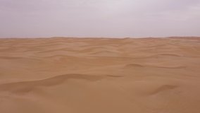 Smooth low angle fpv style drone video of endless sandy Arabian desert. Dry landscape. Untouched nature. 