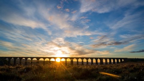 Timelapse during sunrise of The Ribblehead Viaduct a Grade II listed structure, the Viaduct runs the Settle to Carlisle railway route in North Yorkshire, England.