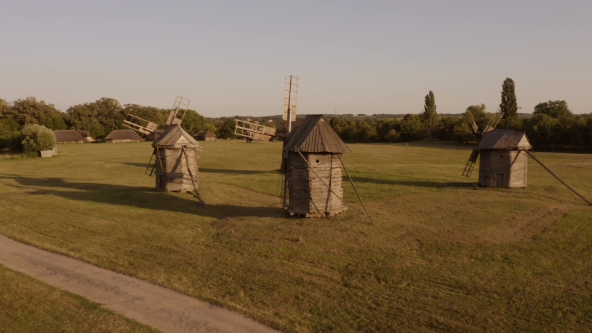 Old rustic mills on the field. Rural landscape with small ancient medieval mills.
