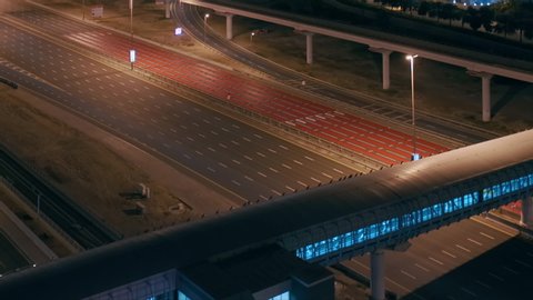 Aerial night view of empty highway and interchange in Dubai after epidemic lockdown. Cityscapes with disappearing traffic on streets. Roads and lanes crossroads without cars, Dubai marina and JLT