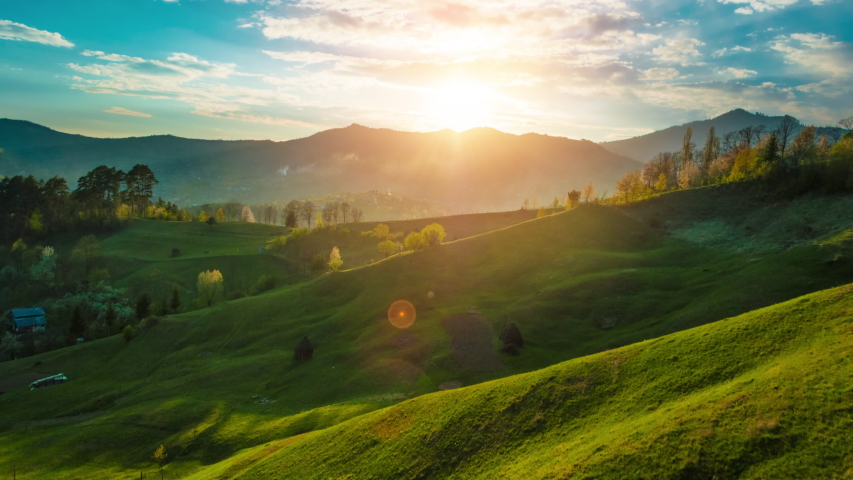 Beautiful sunset light over green grass covered mountain and hills landscape timelapse	
