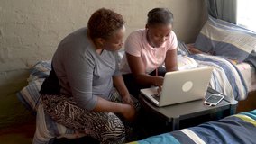 Poverty.Inequality.Black African woman home schooling her daughter at home during lockdown for Covid-19 Coronavirus pandemic, South Africa - Powered by Shutterstock - Get 15% off with code: PIKWIZARD15