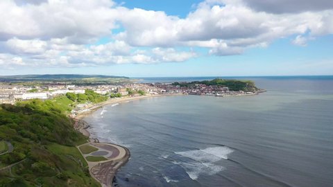 Aerial footage of the beautiful seaside coastal town of Scarborough in the North Yorkshire area in the UK England, showing the beach, harbour and 12th-century historic old Scarborough Castle